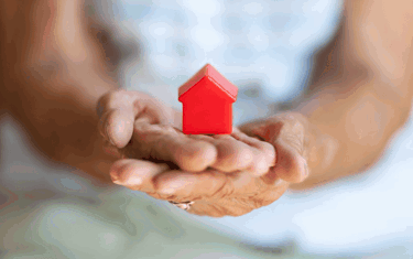 Image of hands holding a small home model display